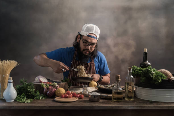 istock Handsome bearded cheef cook prepairing spaghetti on a kitchen, Chef cooks meal 942949228
