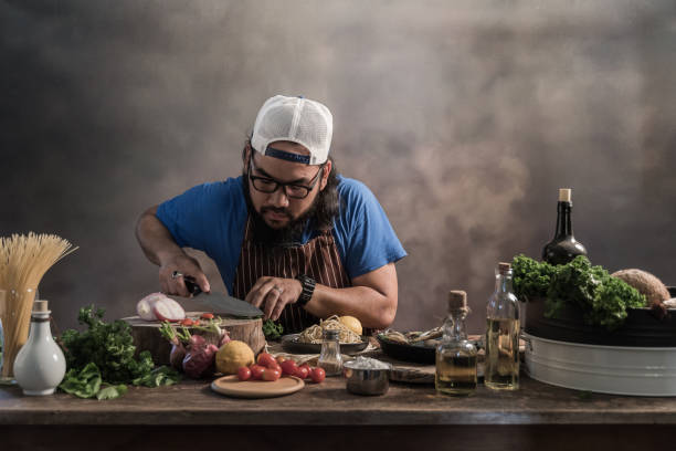 istock Handsome bearded cheef cook prepairing spaghetti on a kitchen, Chef cooks meal 942949230