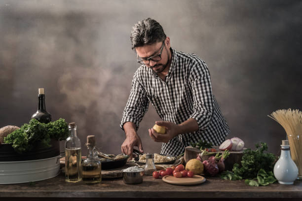 istock Handsome bearded cheef cook prepairing spaghetti on a kitchen, Chef cooks meal 942949244