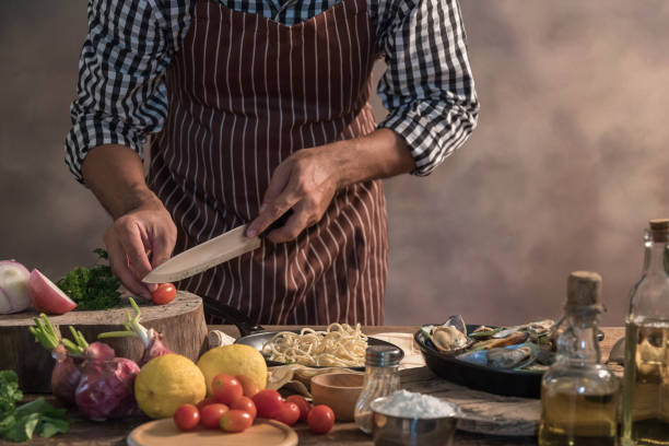 istock Handsome bearded cheef cook prepairing spaghetti on a kitchen, Chef cooks meal 942949266
