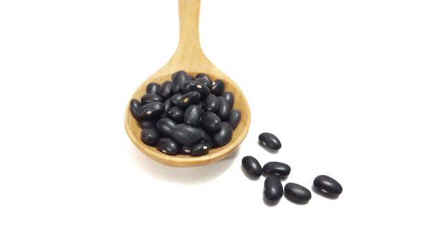 istock Black beans on wooden spoon 942949424