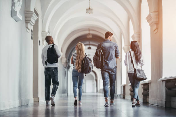 Students in university Multiracial students are walking in university hall during break and communicating. college stock pictures, royalty-free photos & images