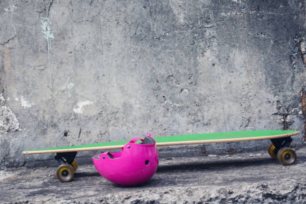 istock Green longboard against a rough concrete wall. 942966714