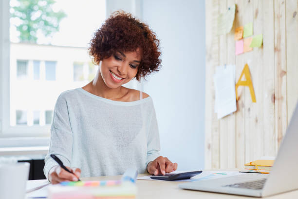 istock Happy woman working at home calculating finances 942969712