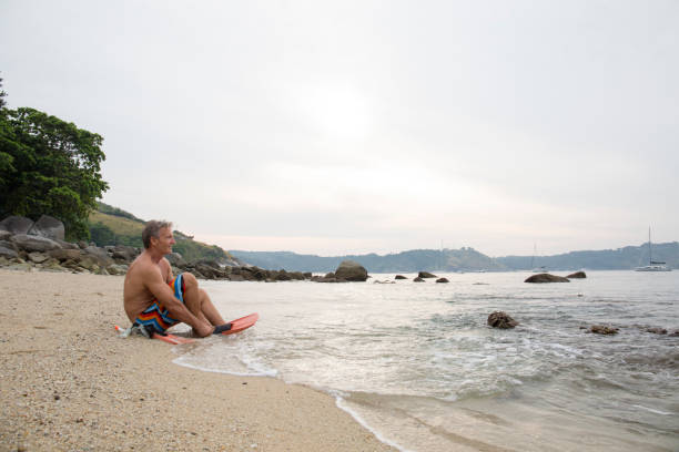 istock Man prepares to go snorkelling on beach 942974528