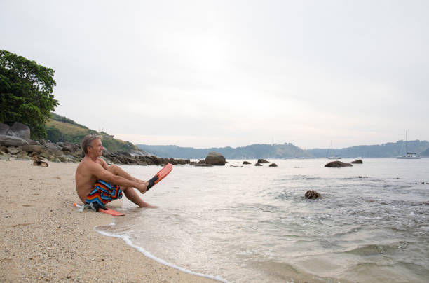 istock Man prepares to go snorkelling on beach 942974548