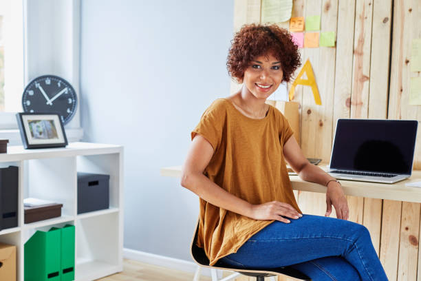 istock Happy young student sitting by desk at home working on laptop 942974594