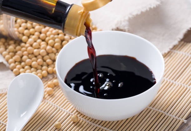 Pouring soy sauce into a white bowl Soy sauce and beans soia sauce stock pictures, royalty-free photos & images