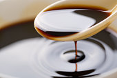 Soy sauce poured from a spoon
