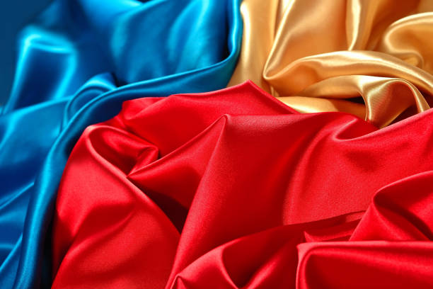 istock Natural golden, blue and red satin fabric texture 942987930