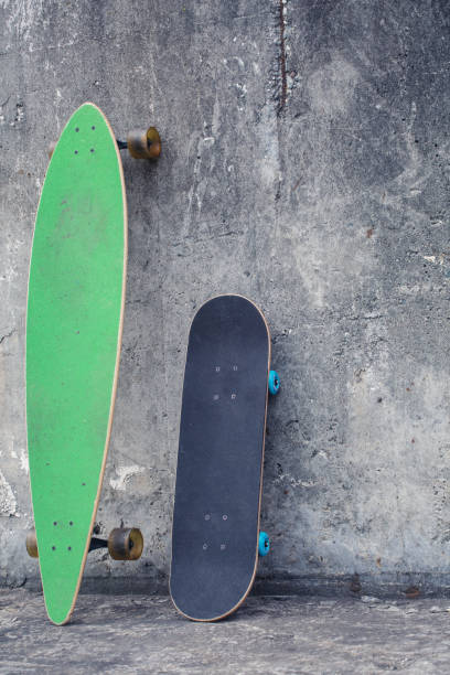 istock Skateboard against a rough concrete wall. 942989260