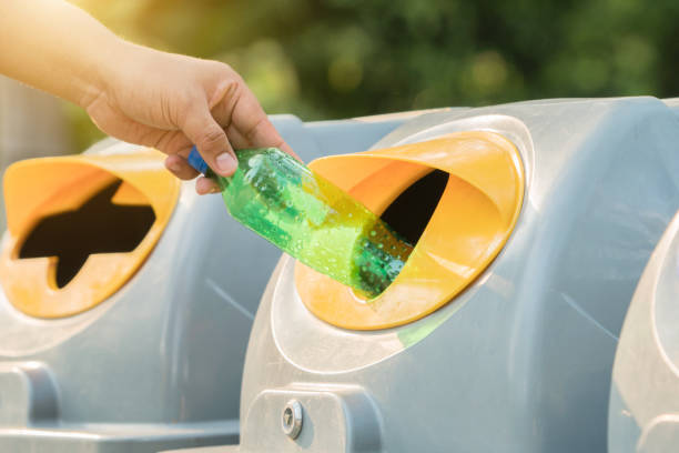 istock Male hand throwing empty plastic bottle into the trash. 942992248