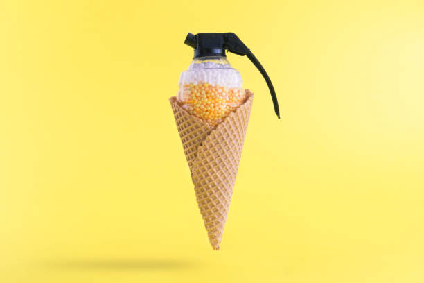 istock Bomb toy in cone against pastel yellow background. 942992392