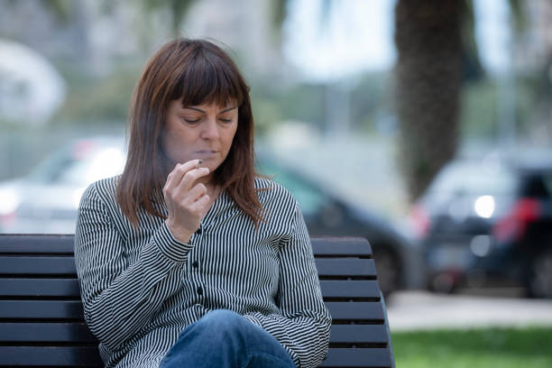 istock Adult Woman Smokes on a Bench 942993228