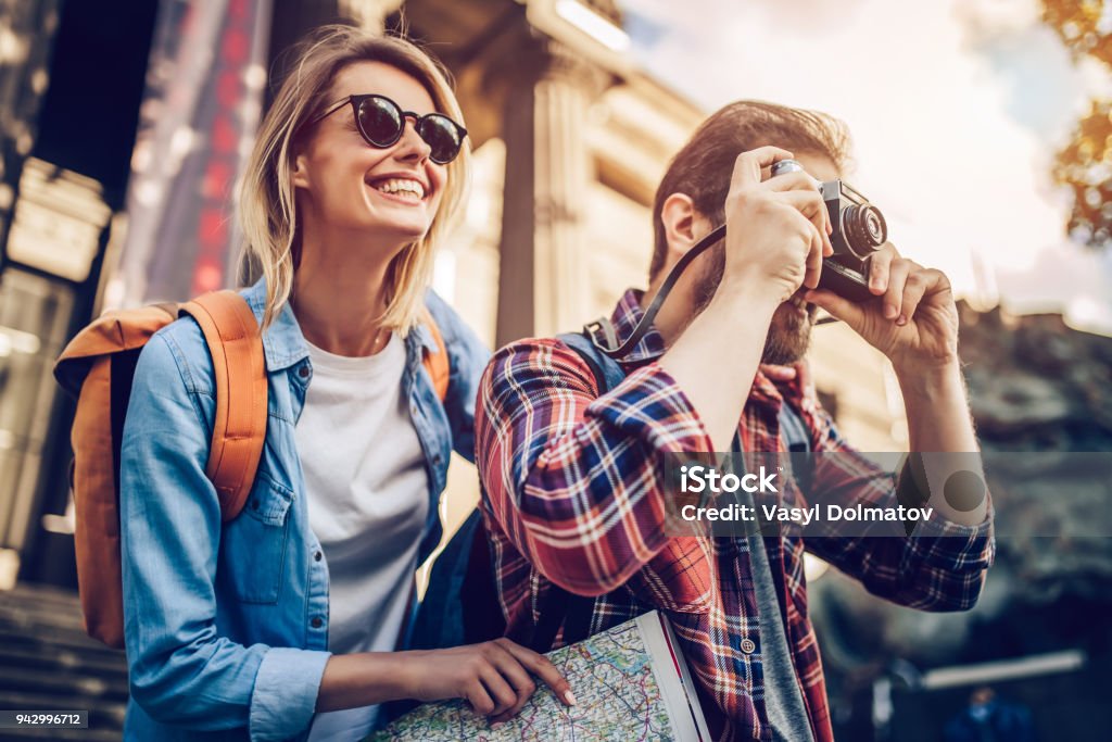 Couple of tourists Couple of tourists is exploring new city together. Smiling and making photo on a retro camera. Travel Stock Photo