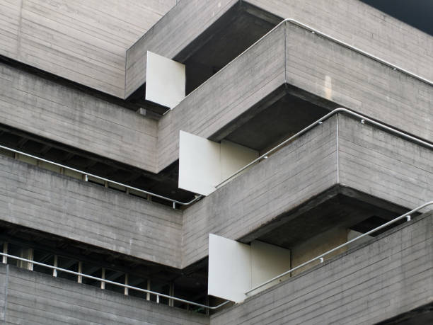 Parts of the brutalist architecture facade of the National Theatre in London against a blue sky
