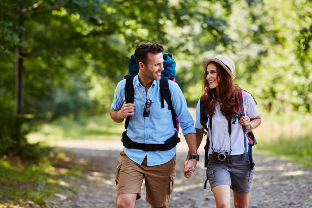 pareja feliz caminar juntos en las montañas con mochilas - people traveling friendship backpack expressing positivity fotografías e imágenes de stock