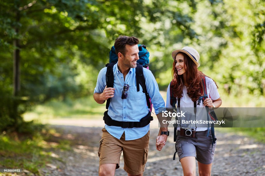 Happy couple hiking together in mountains with backpacks Hiking Stock Photo