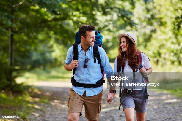 Happy Couple Hiking Together In Mountains With Backpacks Stock Photo - Download Image Now