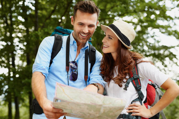 istock Happy couple hiking and reading map 943004390
