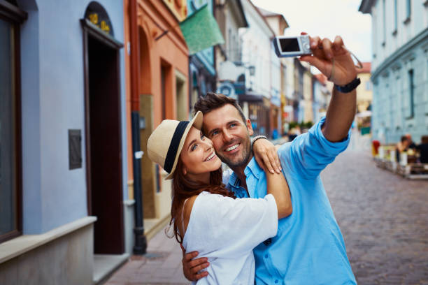 happy couple of tourists taking selfie in old city - vacations two generation family caucasian friendship imagens e fotografias de stock