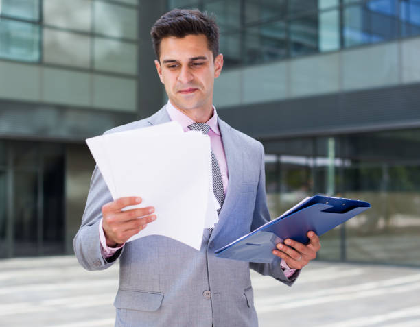 istock Satisfied businessman holding agreement papers 943006070