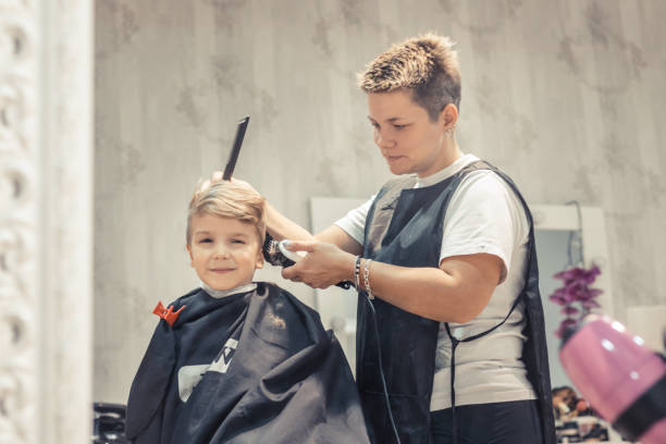 istock Small boy getting a haircut at barber shop. 943011770