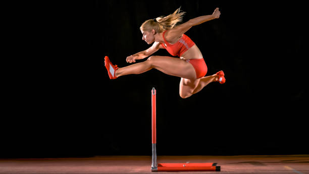 istock Female hurdler jumping over hurdle 943018920