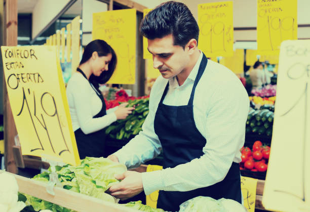 istock shop people standing near cabbage in grocery 943019174