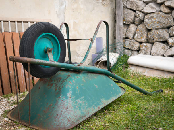 Green wheelbarrow lying on a green meadow in Lubenice, Cre Croatia