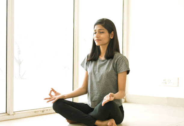 istock Young woman meditating 943026494