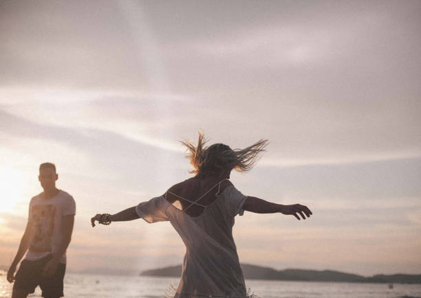 istock Couple having fun in the sea at sunset beach 943029794