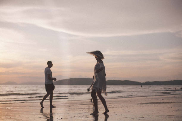 istock Couple having fun in the sea at sunset beach 943029796
