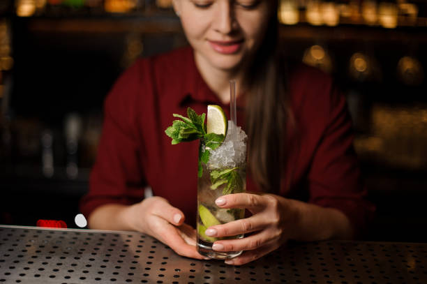 istock barmaid is standing at the bar and holding a ready-made mojito 943030936