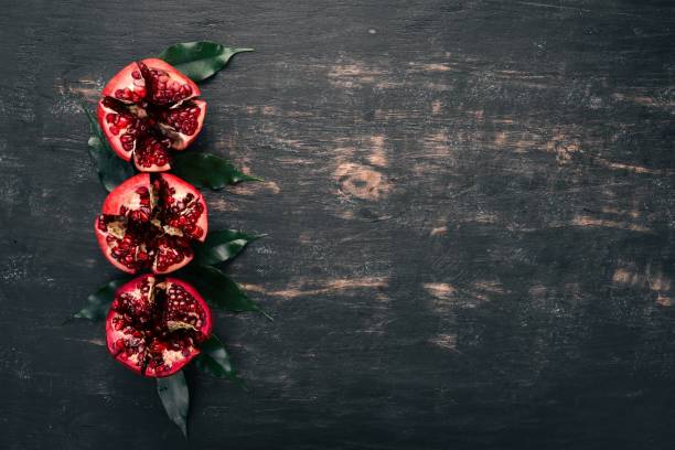 istock Fresh pomegranate. On a black wooden background. Top view. Copy space. 943030990