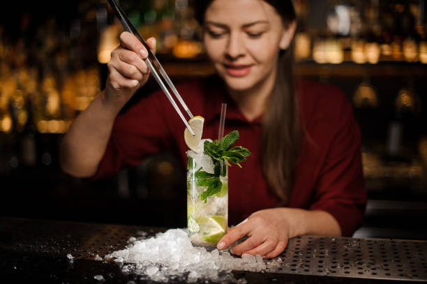 istock barmaid completes the design of the mojito, adding slice of lime 943031400