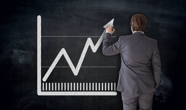 istock Businessman paints chart on blackboard concept 943033812