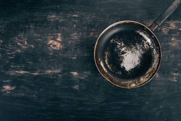 istock An old frying pan on a wooden background. Top view. Copy space for your text. 943034482