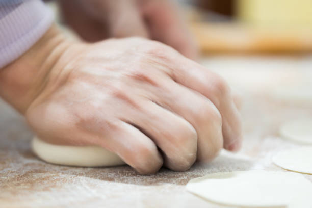 istock Close-up of hands kneading dough 943038340