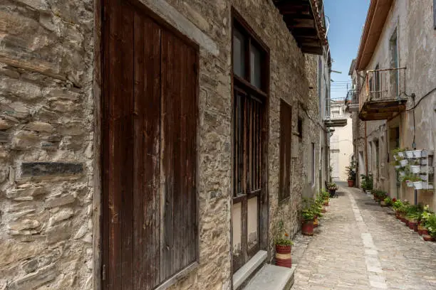 A beautiful street in Lefkara, Cyprus, showing potted plants along the old pebbled kerb. A village full of culture and history. Famous for its Lace making