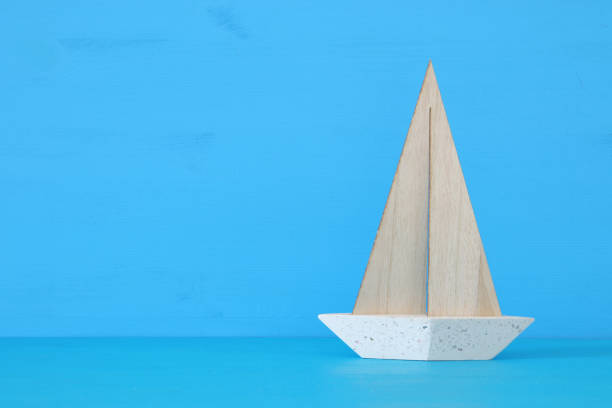 istock nautical concept with white decorative sail boat over blue wooden table and background. 943041462
