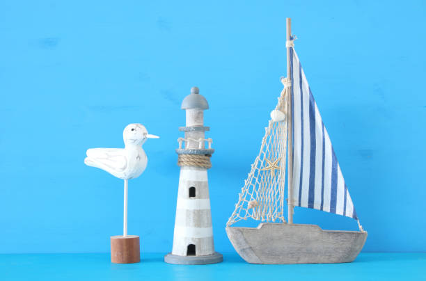 istock nautical concept with white decorative seagull bird, lighthous, and boat oars over blue background. 943041550