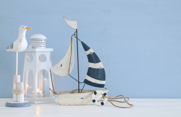 istock nautical concept image with white decorative seagull bird, boat and lighthouse lantern over light blue background. 943041698