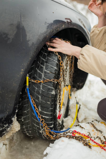 istock Beautiful woman installing snow chain on her car 943044986