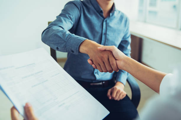 istock Smiling Asian businessman shaking partners hand 943045028