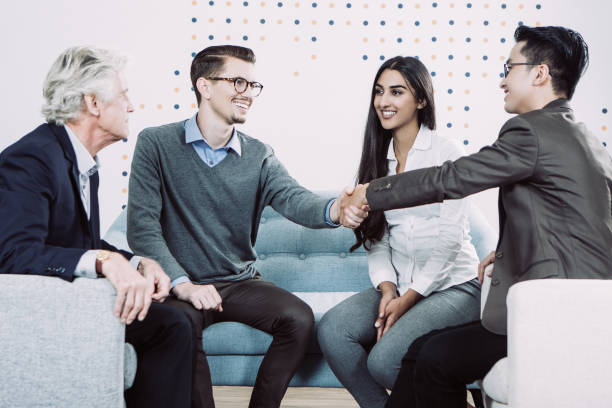 istock Smiling Business Partners Shaking Hands in Lounge 943045354