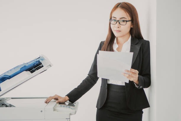 istock Young Asian Business Lady Using Photocopier 943045400