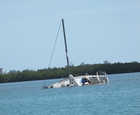 Capsized sailboat on a lagoon.