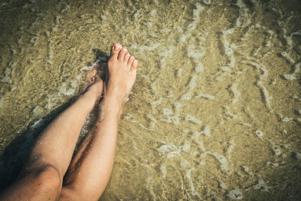 istock Sexy Legs on Beach Top View 943055700