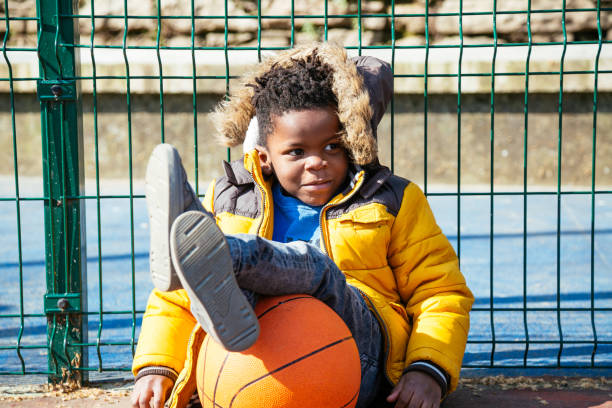 istock Funny little boy resting after playing basketball 943058304